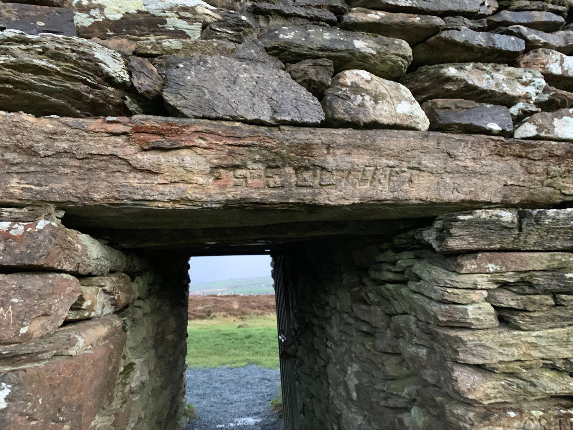 Close-up of the inscribed lintel and dry-stone masonry above the ringfort doorway